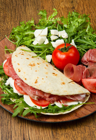 italian piadina with ham, fresh salad and mozzarella cheeseの写真素材