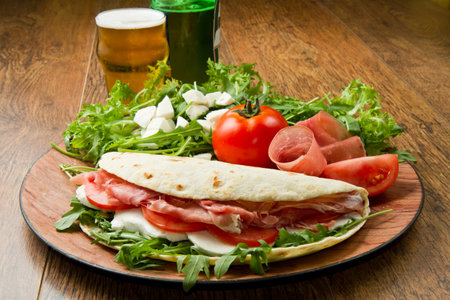 italian piadina with ham, fresh salad and mozzarella cheeseの写真素材