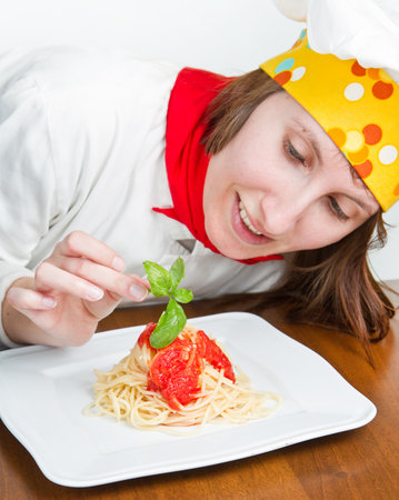  smiling chef garnish an Italian pasta dish の写真素材