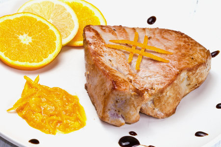 fried tuna fillet with fresh orange and orange sauceの写真素材
