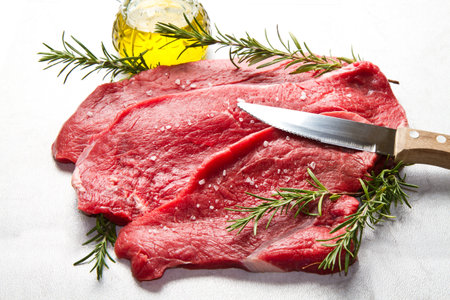 a red meat with  rosemary on marble tableの写真素材