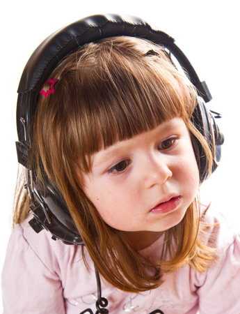 Beautiful cute happy little girl with headphones の写真素材