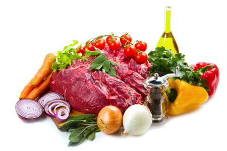huge red meat chunk with vegetables isolated over white background の写真素材