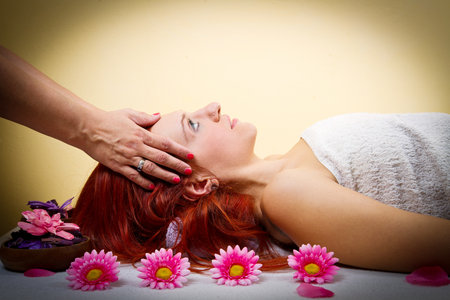 Beautiful young woman receiving facial massage in a spa salonの写真素材