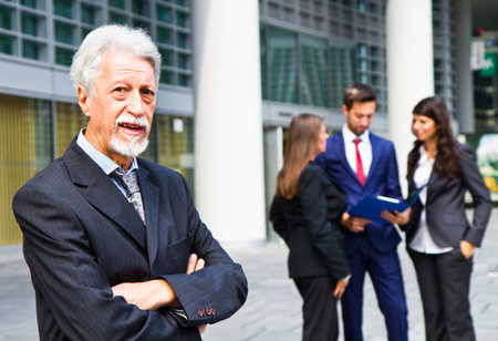 Beautiful man on the background of business peopleの写真素材