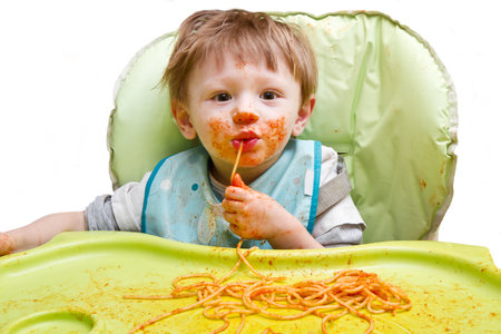 Little blond boy eating spaghettiの写真素材