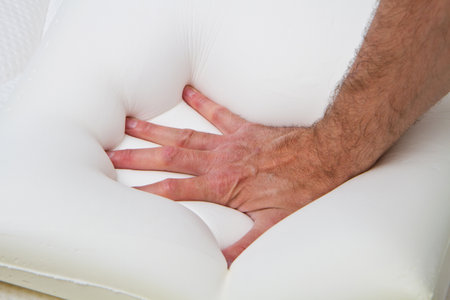 male hand touching and testing mattress