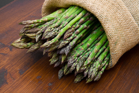 asparagus in burlap sack on woodの写真素材