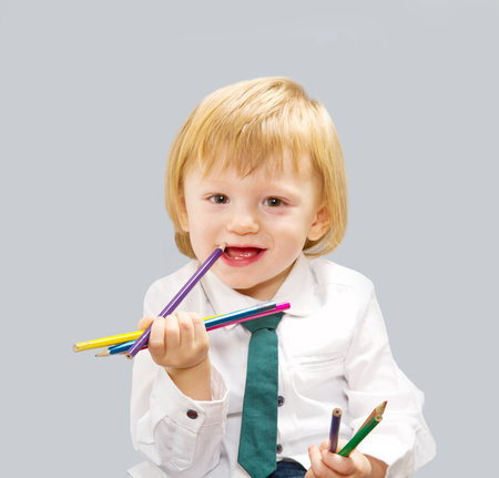 little cute boy with color pencilsの写真素材