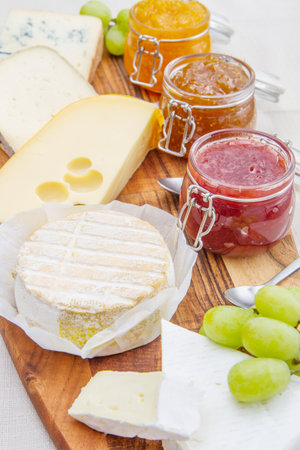 wooden cutting board with cheese and jamsの写真素材