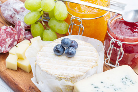 wooden cutting board with cheese, cold cuts and jamsの写真素材