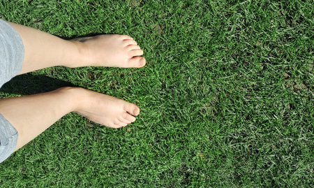 baby barefoot on the grass lawnの写真素材