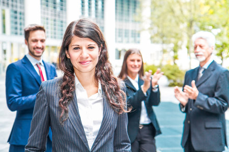 Beautiful woman on the background of business peopleの写真素材
