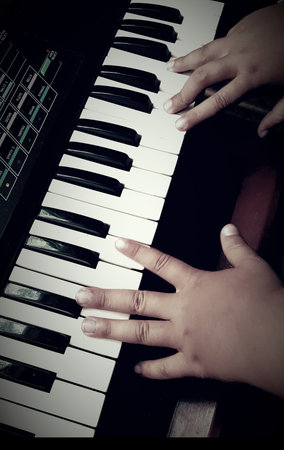 Hands of little girl playing the pianoの写真素材