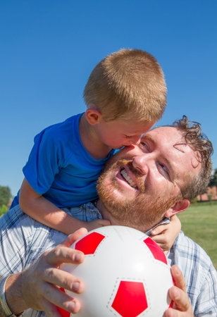 Dad and son play together with the ballの写真素材