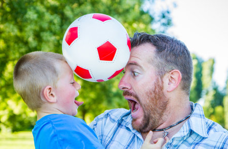 Dad and son play together with the ballの写真素材