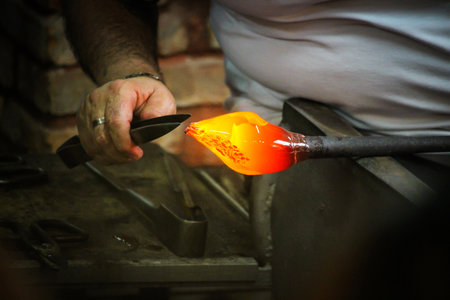 Glass Artist in her workshop making glassware の写真素材
