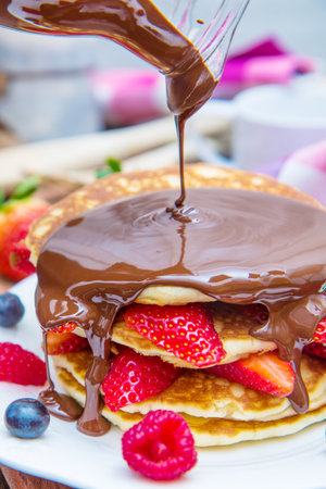 dish with pancakes and strawberry, raspberry and blueberry and chocolateの写真素材