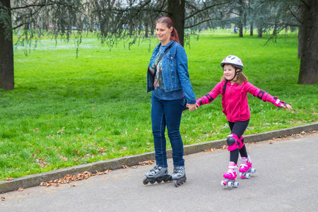 mother and daughter into the park with roller skatesの写真素材