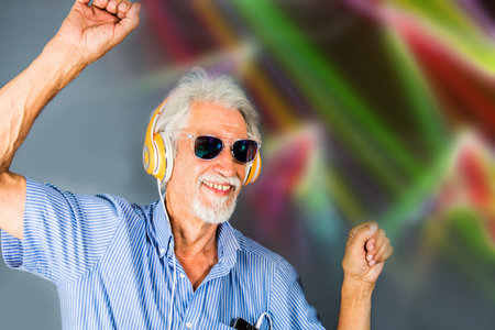 elderly man listen music with headphone and danceの写真素材