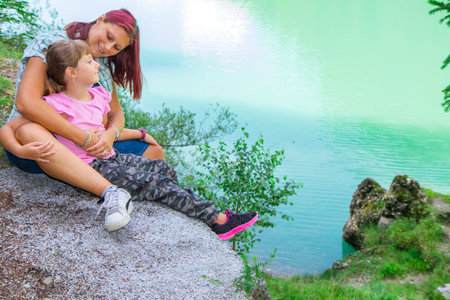 mom and daughter looking each other during an excursion to the lakeの写真素材