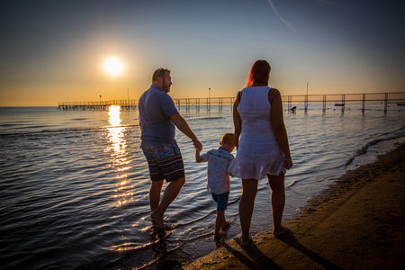 happy family walking on the shoreの写真素材