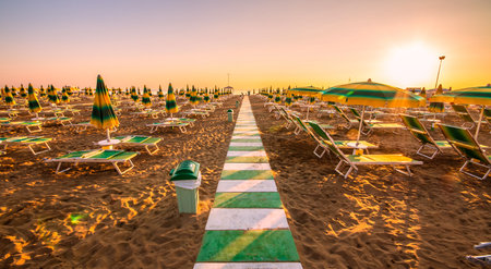closed umbrellas and deck chairs on the beachの写真素材