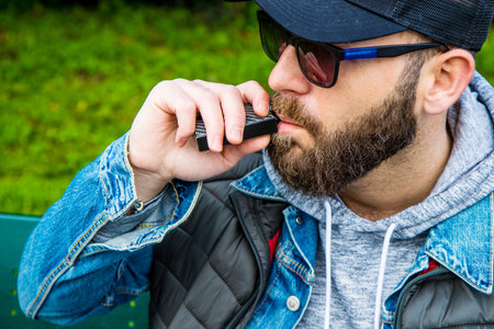 man with a beard smokes an electronic cigaretteの写真素材