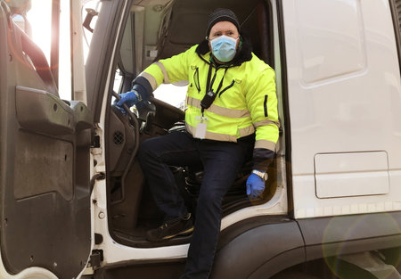 young transporter on the truck with face mask and protective gloves for Coronavirus
