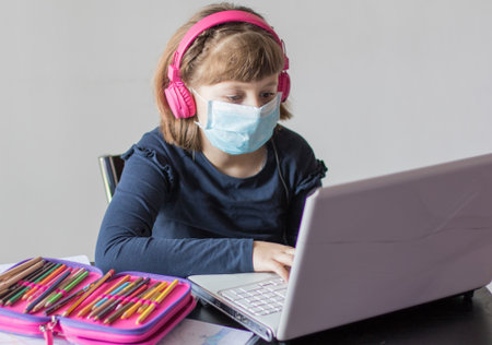 Young girl studying homework math during her online lesson at home, social distance during quarantine, self-isolation, online education concept, home schoolerの写真素材