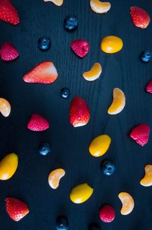 top of view of Colorful pattern made of tangerine, raspberry, blueberry and strawberries.