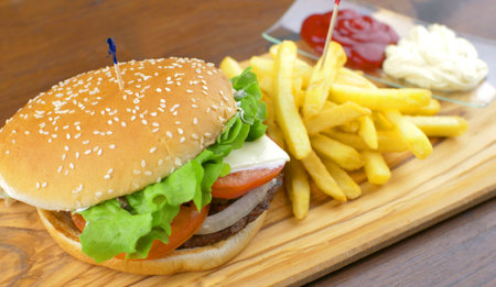 Delicious grilled hamburger with potato chips on wooden boardの写真素材