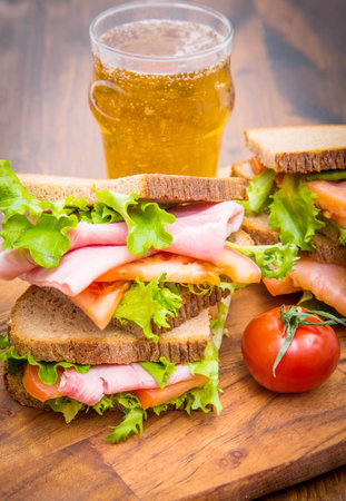 sandwiches with ham and smoked salmon with beer glassesの写真素材