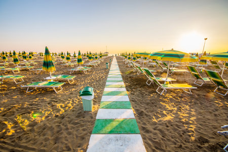 closed umbrellas and deck chairs on the beachの写真素材