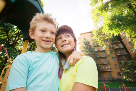 brother and sister are hugging each other in a sunny day in the parkの写真素材