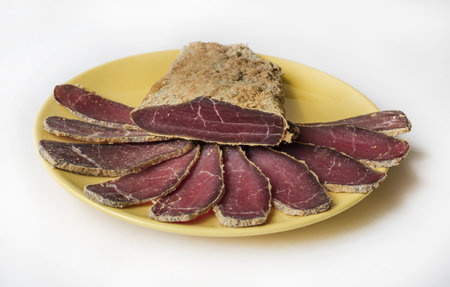 Armenian basturma - jerky beef meat with spices on a yellow plateの写真素材