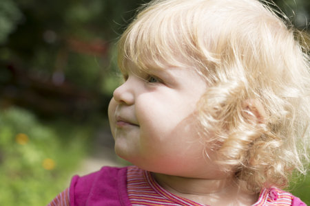a girl one and a half years of walking in the garden in summerの写真素材