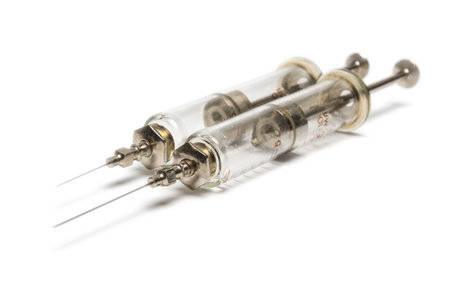 two old medical syringes from glass and metal. isolatedの写真素材