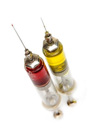 two old medical syringes from glass and metal with medication and bloodの写真素材