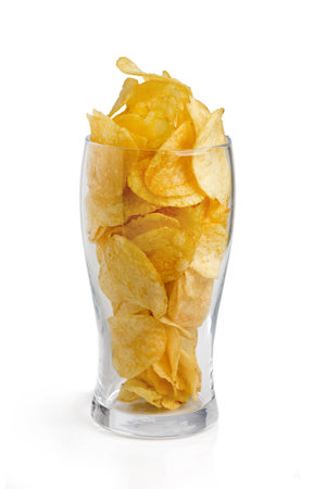 Potato chips poured into a glass of beerの写真素材