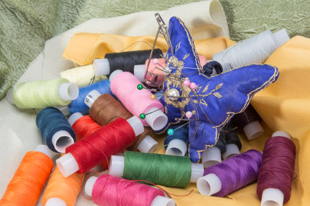 needle and thread on background fabrics for sewing
