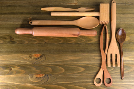 A set of wooden kitchen utensils on a dark boardの写真素材