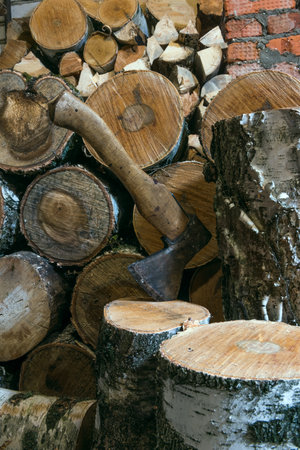 ax and birch firewood stacked in a barn
