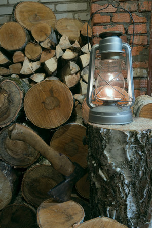 oil lamp, an ax and birch firewood stacked in a barnの写真素材