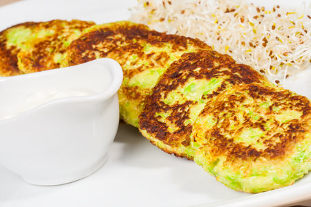 Zucchini fritters with sour creamの写真素材