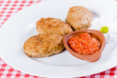 Beef cutlets with tomato sauce on white plateの写真素材