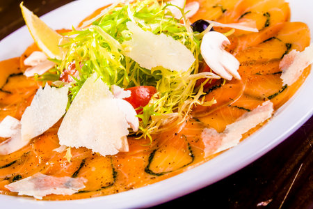 Appetizer. Salmon carpaccio with parmesan cheese on white plateの写真素材
