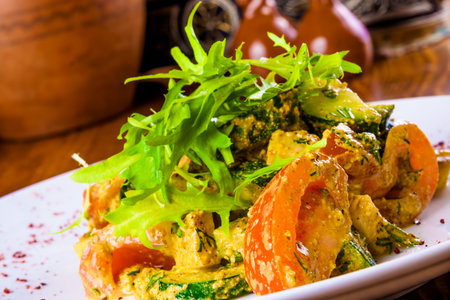 Traditional Georgian salad with tomatoes, cucumbers and walnut sauce on white plateの写真素材