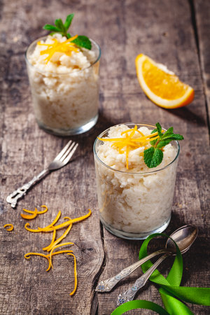 Two glasses of rice pudding on wooden rustic table. Close upの写真素材