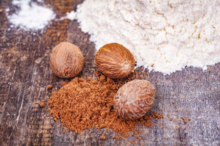 Nutmeg and flour. Ingredients for preparing bechamel sauce on wooden table. Close upの写真素材
